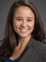 Alana Laanui, female with dark hair, wearing a dark grey blazer and royal blue blouse